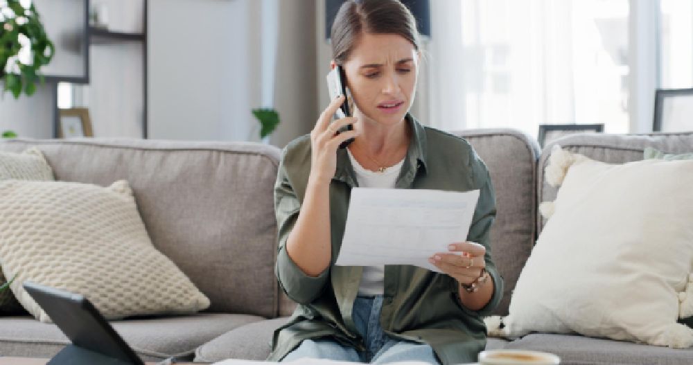 Woman stressed about her energy bill because of drafty windows